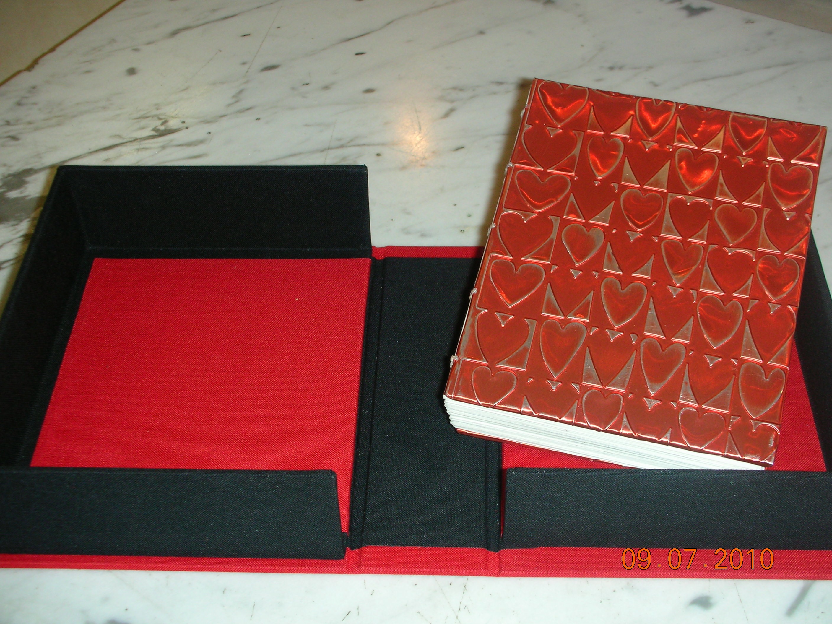 Bk w_alum.embossing in clamshell.jpg Book with aluminum embossing in clamshell
